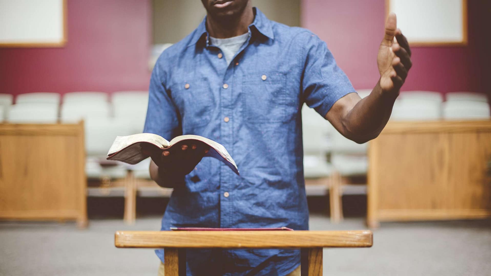 Pastor preaching from the Bible at a pulpit, emphasizing effective church communication and message delivery.